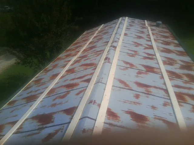 Rusted metal roof panels with new wood purlins before replacement — Storm Damage Roof Repair in Marshville by Roofing Brothers