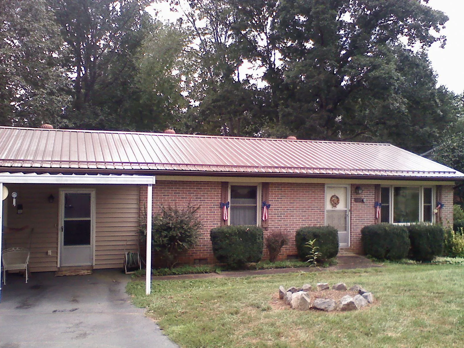 Bronze metal roof and carport on a brick ranch home — Roof Repair work by our crew in Marshville